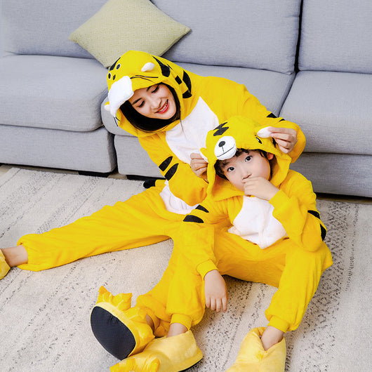 Young child in a yellow tiger hooded flannel pajama jumpsuit with white belly and black stripes, standing indoors. - Image 4