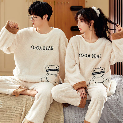 Couple wearing matching cream coral fleece pajamas with gray pants and bear embroidery, seated on a bed. - Image 3