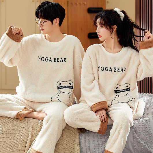 Couple wearing matching cream coral fleece pajamas with gray pants and bear embroidery, seated on a bed. - Image 3