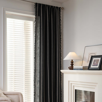 Black polyester curtain with white jacquard multi-line pattern and black tassels, draped over a white chair. - Image 17