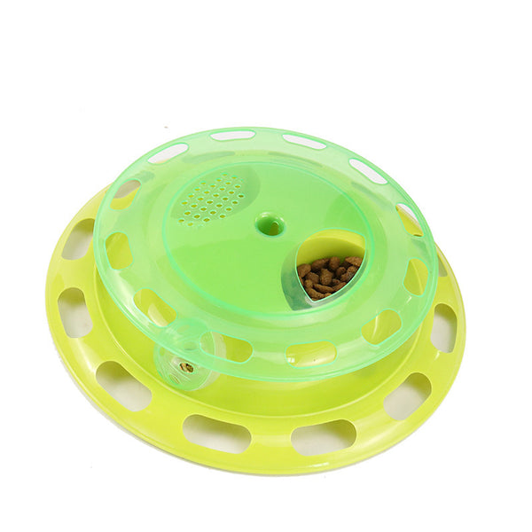 Green and yellow two-tier interactive cat toy turntable with a bell ball in the track and kibble in the top compartment.