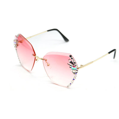 Women's frameless sunglasses with brown gradient lenses and colorful rhinestone embellishments on gold metal temples.
