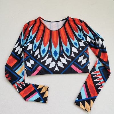 Women's long-sleeve crop top and high-waisted bikini set with a vibrant red, blue, black, and white feather-like geometric pattern. - Image 3