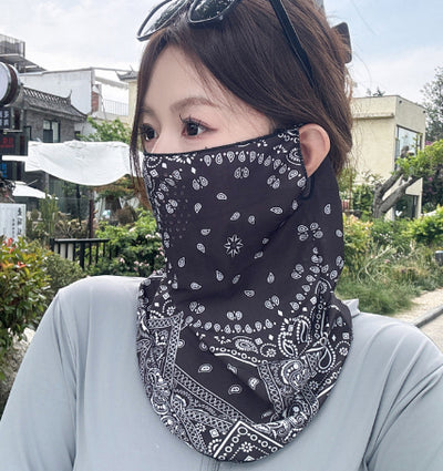 Black paisley sun mask with white pattern and ear loops, covering the lower face and neck, worn outdoors. - Image 6