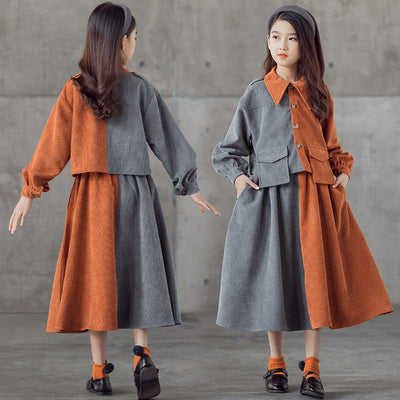 Young girl in a pink and brown color-block corduroy two-piece dress set with a collared top and midi skirt.