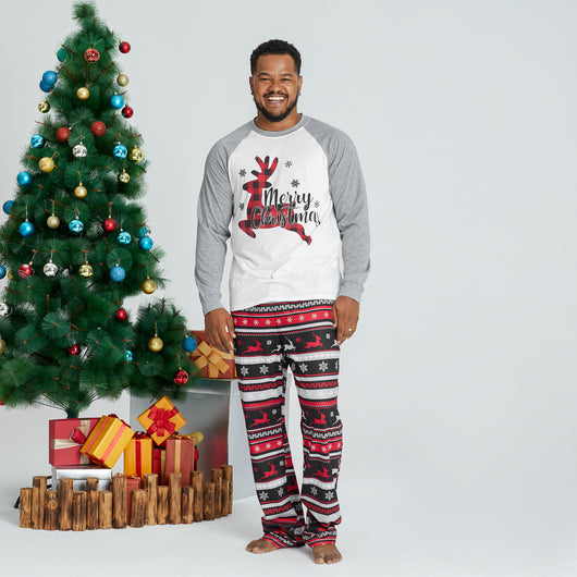 Woman wearing a white and grey long-sleeve Christmas pajama top with a plaid reindeer and patterned holiday pants. - Image 4