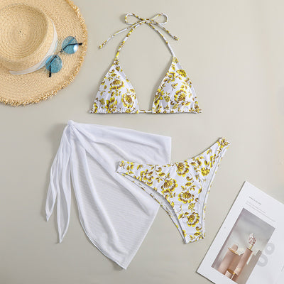 White and yellow floral print three-piece bikini set with a halter triangle top, high-cut bottom, and sheer white sarong. - Image 6