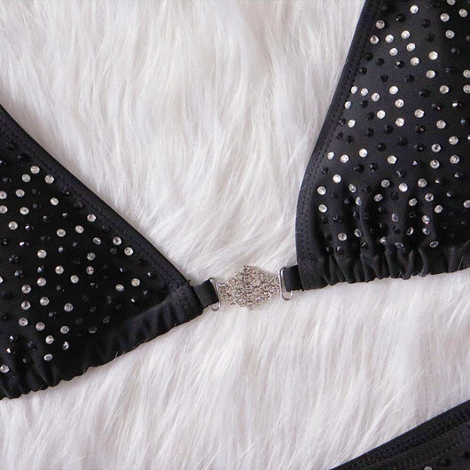 Black two-piece bikini with rhinestone chain halter straps and connectors, laid flat on white faux fur. - Image 10