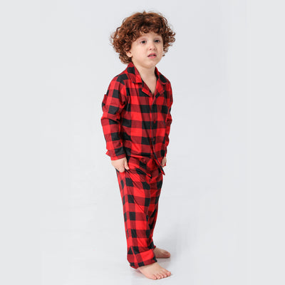 Baby in a red and black buffalo plaid long-sleeve pajama romper, viewed from the back with arms raised. - Image 21