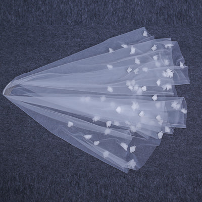White and ivory sheer fabric swatches for a wedding veil displayed on green grass. - Image 8