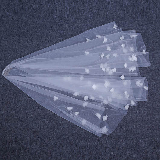 White and ivory sheer fabric swatches for a wedding veil displayed on green grass. - Image 8
