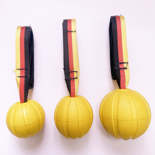 Yellow EVA pet training ball with a black, red, and yellow striped tether, designed for water play. - Image 11