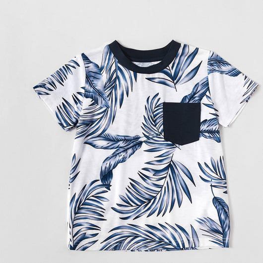 Young boy wearing a white short-sleeve t-shirt with blue tropical leaf print and a black chest pocket. - Image 23