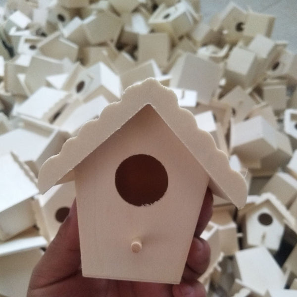 Unfinished wooden birdhouse with a circular entrance hole and a small perch, held by a hand.