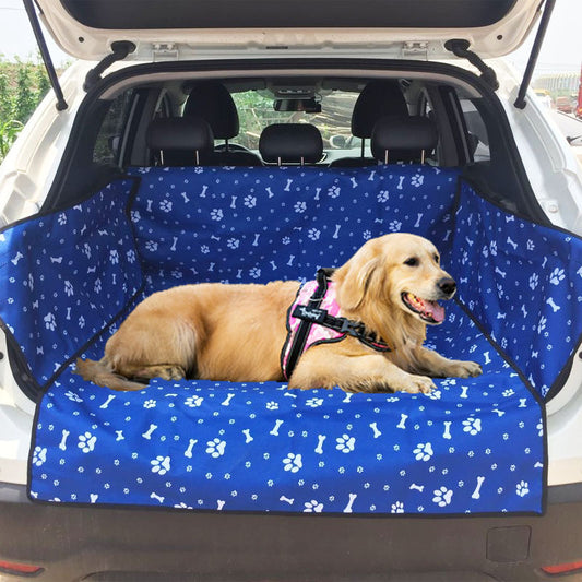 Blue waterproof pet car mat with white paw print and bone patterns installed in the trunk of a white SUV.