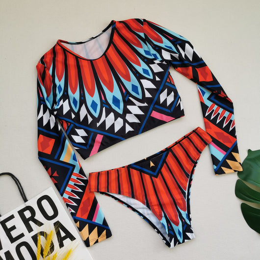 Women's long-sleeve crop top and high-waisted bikini set with a vibrant red, blue, black, and white feather-like geometric pattern. - Image 7