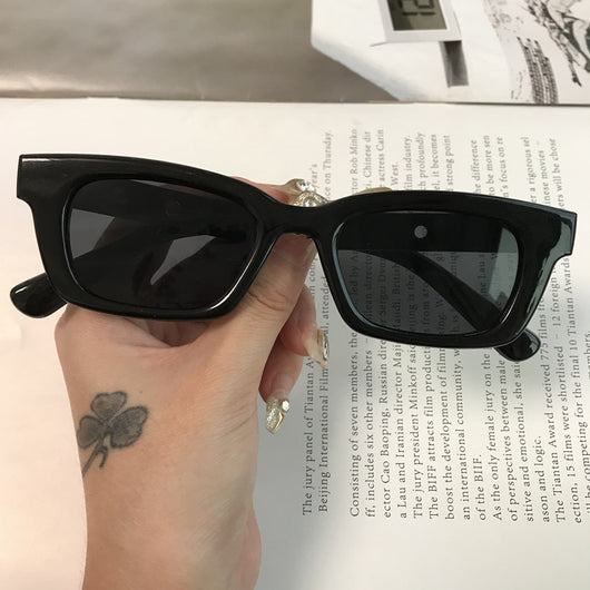Square retro tortoise shell sunglasses with dark lenses, held by a hand against a blurred magazine background. - Image 7