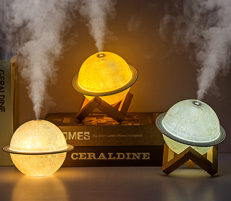 White moon-shaped humidifier with a textured surface resembling craters and a thin ring around its middle.