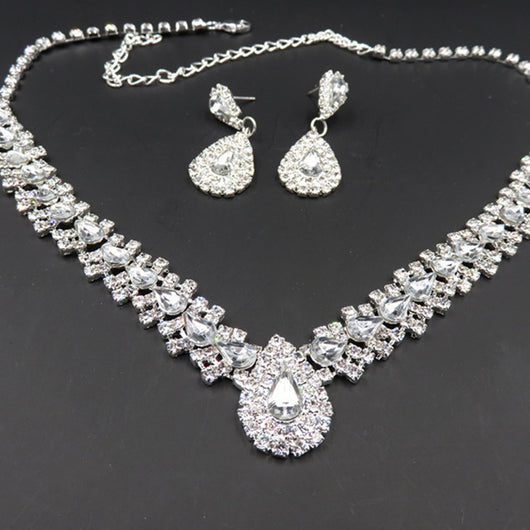 Sparkling silver-tone bridal jewelry set with a rhinestone necklace and matching teardrop drop earrings on a black bust. - Image 3