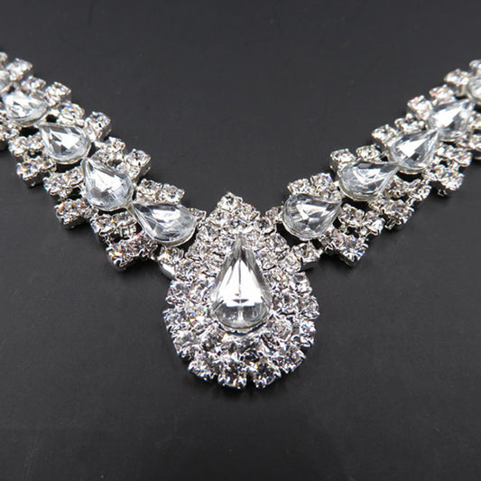 Sparkling silver-tone bridal jewelry set with a rhinestone necklace and matching teardrop drop earrings on a black bust. - Image 2