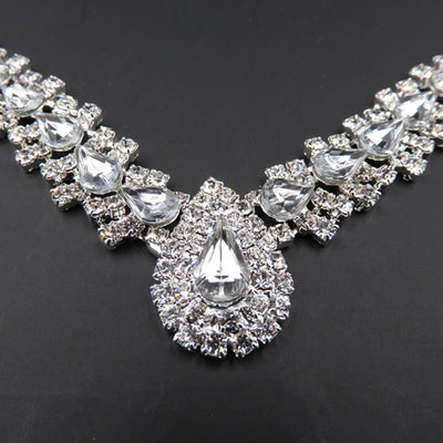 Sparkling silver-tone bridal jewelry set with a rhinestone necklace and matching teardrop drop earrings on a black bust. - Image 2