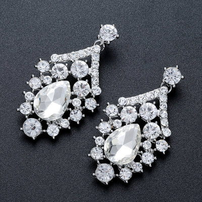 Sparkling silver-tone necklace and matching earrings set with clear round and teardrop rhinestones on a black display. - Image 2