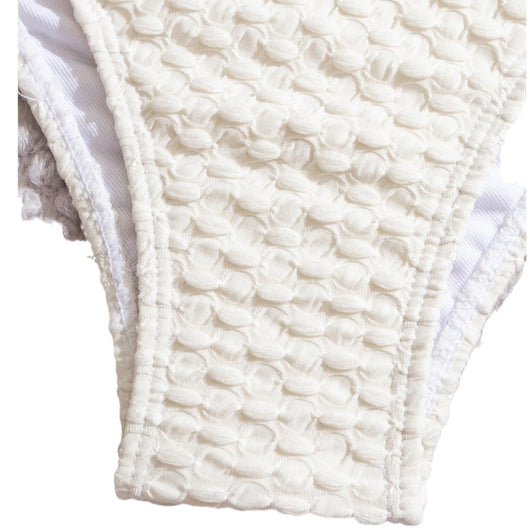 Off-white textured two-piece women's swimsuit with a bandeau halter top and high-cut bottoms, displayed with a straw hat and sunglasses. - Image 5