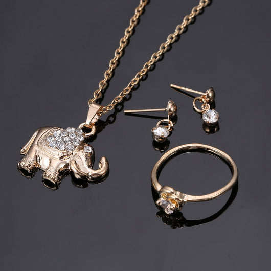 Rose gold-toned jewelry set with an elephant pendant necklace, matching rhinestone drop earrings, and a heart-knot ring. - Image 3