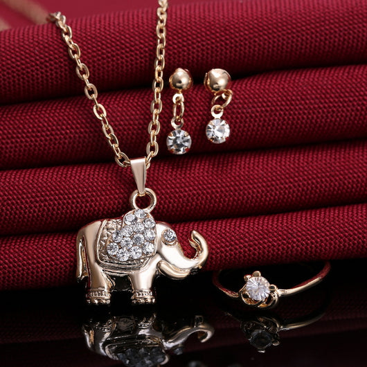 Rose gold-toned jewelry set with an elephant pendant necklace, matching rhinestone drop earrings, and a heart-knot ring. - Image 5