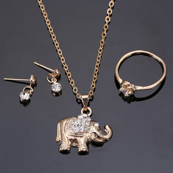 Rose gold-toned jewelry set with an elephant pendant necklace, matching rhinestone drop earrings, and a heart-knot ring.