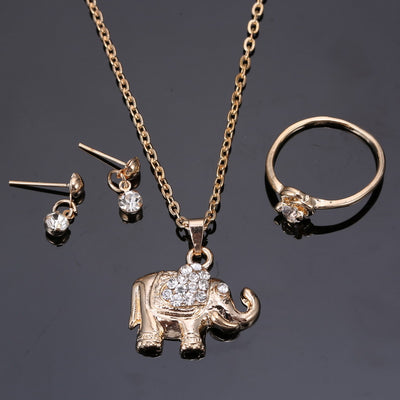 Rose gold-toned jewelry set with an elephant pendant necklace, matching rhinestone drop earrings, and a heart-knot ring.