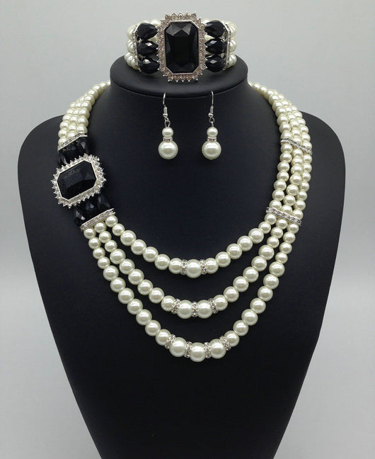 Three-piece jewelry set with multi-strand pearl necklace, blue gemstone pendant, matching pearl drop earrings, and pearl bracelet. - Image 4
