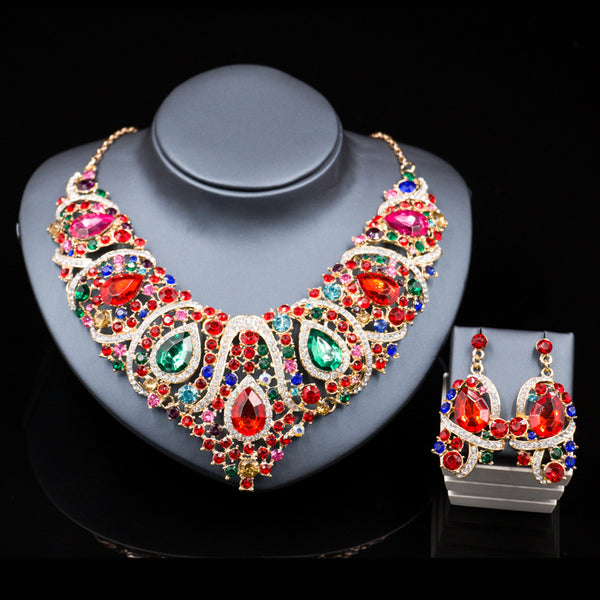 Exaggerated blue rhinestone and pearl bridal necklace and earring set with silver-tone alloy plating.