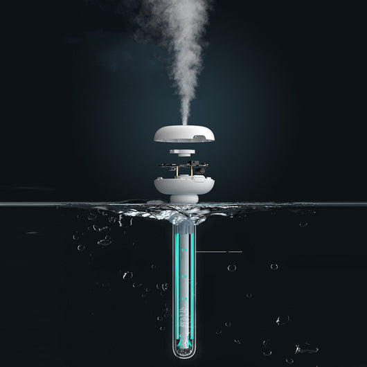 Clear bottle-shaped USB humidifier with a white donut-style top, emitting a stream of cool mist on a wooden table. - Image 6