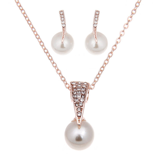 Rose gold-toned necklace and stud earrings set with faux pearls and clear rhinestones, displayed on a white background.