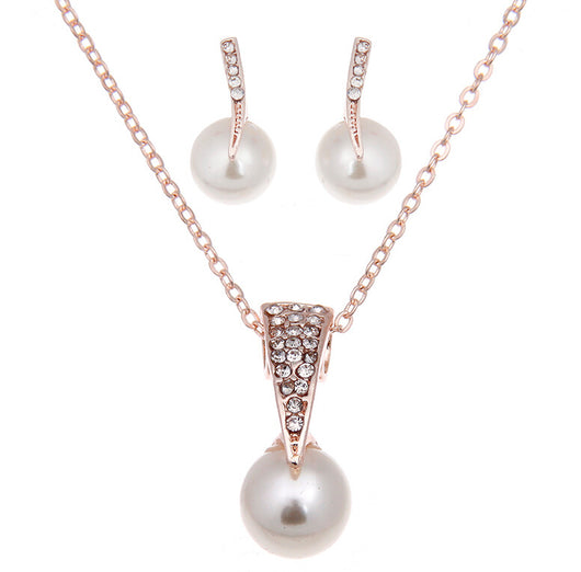 Rose gold-toned necklace and stud earrings set with faux pearls and clear rhinestones, displayed on a white background.