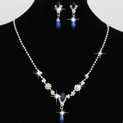 Purple rhinestone and faux pearl necklace and drop earrings set on a black display. Features silver-tone settings. - Image 4