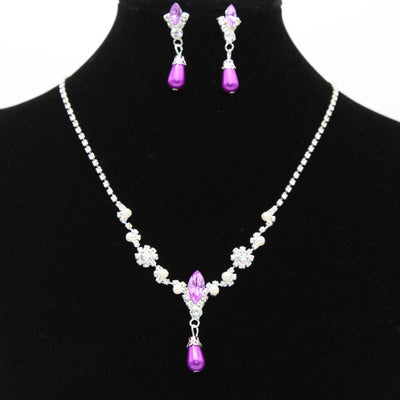 Purple rhinestone and faux pearl necklace and drop earrings set on a black display. Features silver-tone settings. - Image 5