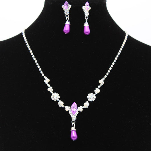Purple rhinestone and faux pearl necklace and drop earrings set on a black display. Features silver-tone settings. - Image 5