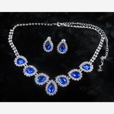 Purple teardrop rhinestone necklace and matching stud earrings set on a black background. - Image 8