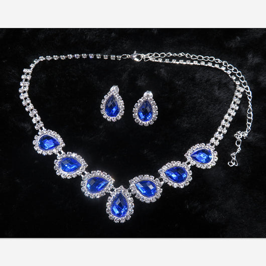 Purple teardrop rhinestone necklace and matching stud earrings set on a black background. - Image 8