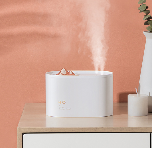 White portable humidifier with rose gold mountain-shaped mist outlet, 1000ml capacity, and compact design.