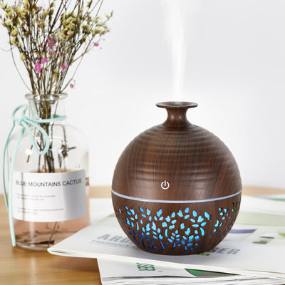 Light wood grain portable mini aroma diffuser humidifier with a vase shape and glowing blue leaf patterns. - Image 8