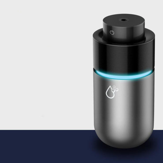 Silver-gray car humidifier and air purifier with a black top, emitting mist and glowing with a blue LED light. - Image 3