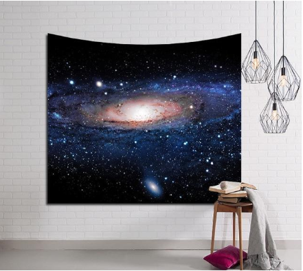 Milky Way galaxy tapestry with a vibrant spiral galaxy and stars, displayed on a white brick wall.
