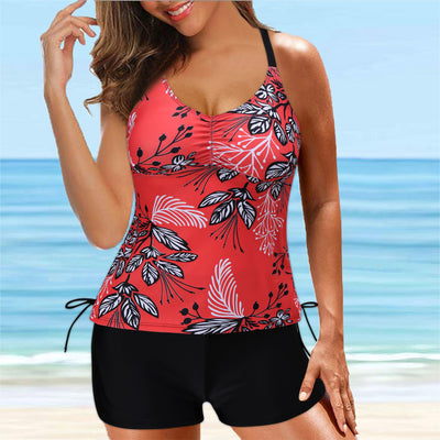 Fuchsia pink tankini swimsuit for women featuring a pleated halter top and matching swim shorts, modeled on a beach.