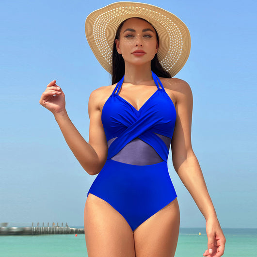 Woman in a green halter-neck one-piece swimsuit with cross-strap design and mesh cutouts, on a beach. - Image 24