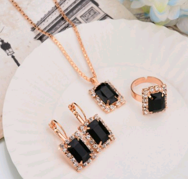 Rose gold-toned necklace, earrings, and ring set with large oval clear gemstones surrounded by smaller stones. - Image 26