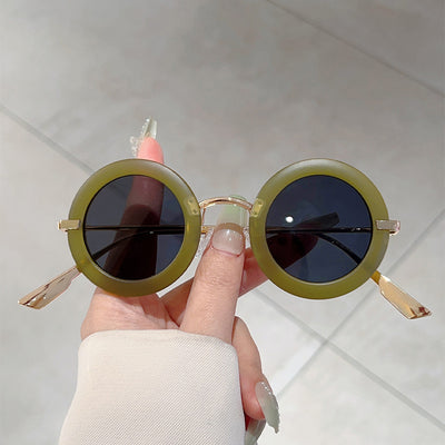 Small frame oval fashion sunglasses with black frames and vibrant orange lenses, held by a hand. - Image 12