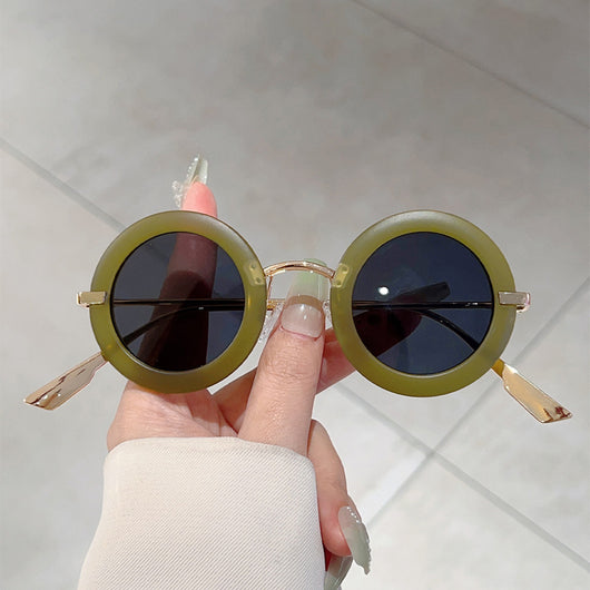 Small frame oval fashion sunglasses with black frames and vibrant orange lenses, held by a hand. - Image 12